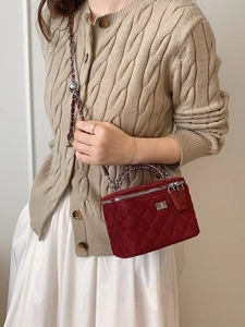 Red quilted velvet vanity crossbody bag with silver chain strap worn by a female model