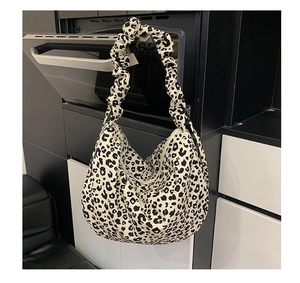 Detail of leopard print hobo bag with wide pleated shoulder strap and crescent shape