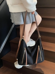 Large black suede tote bag with brown straps and vertical zippers for casual commuting
