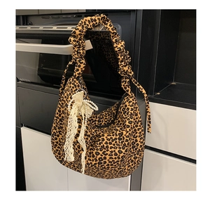 Detail of leopard print tote bag with pearl lace bow charm and ruffled shoulder strap