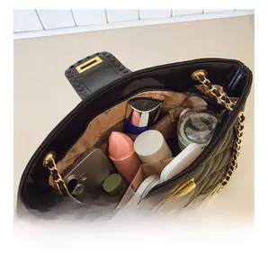 Detailed interior view of quilted leather shoulder bag with multiple compartments and gold chain