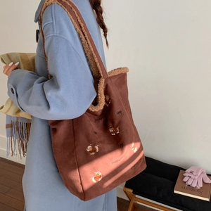 Detail of dark brown corduroy tote with puppy embroidery and faux shearling lining trim