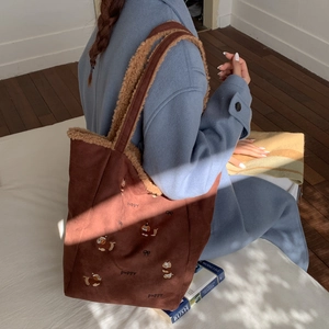 Close-up of brown corduroy tote with fleece trim and puppy embroidery in casual setting