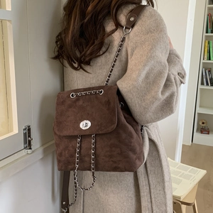 Détail d'un sac à dos en daim marron avec matelassage et boucle rotative en métal
