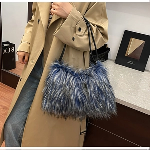 Chic faux fur shoulder bag with blue mixed textures and black leather handles on a model