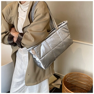 Macro detail of silver quilted puffer tote bag with metallic finish and soft cotton filling