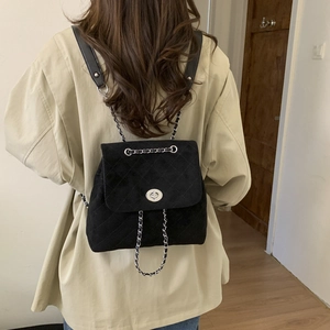 Vue de dos d'un mannequin portant un sac à dos en daim noir matelassé avec chaînes