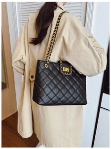 Détail du sac à bandoulière en cuir noir matelassé avec garnitures dorées et chaînes