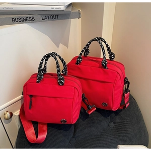 Detailed view of red nylon crossbody bags with polka dot rope handles and metal logo