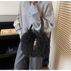 Close-up of black curly plush faux fur bag with silver metal turn-lock and leather strap