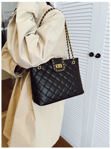 Détail du sac cabas en cuir matelassé avec chaînes dorées et fermoir rotatif