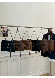 Collection of vintage matte leather tote bags in multiple colors with gold metal buckles