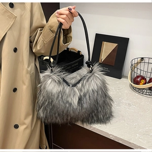 Detail view of a plush grey faux fur handbag with sleek black leather shoulder strap