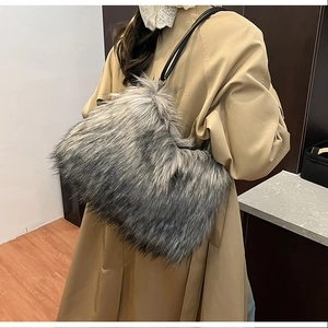 Close-up of fluffy faux fur shoulder bag in grey-black gradient with a slim leather strap
