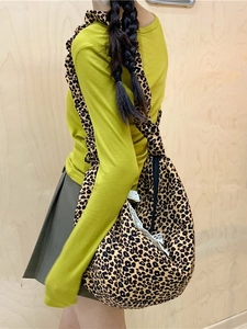Leopard print hobo bag with white lace trim and wide strap shown on model's shoulder