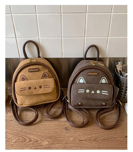 Detailed view of mini cat-shaped backpacks in khaki and dark brown matte textures