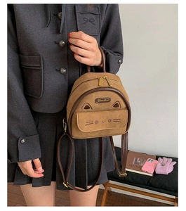 Close-up of cute cat backpack in brown faux suede with detailed ear and whisker embroidery