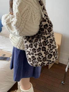 Faux fur leopard print large tote bag for women shown in a cozy indoor lifestyle setting