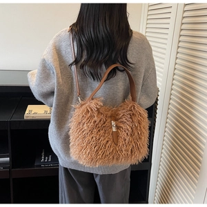 Brown fluffy faux fur tote bag with leather straps worn by model in a stylish room