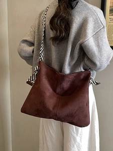 Dark brown suede tote bag featuring a stylish black and white striped wide shoulder strap