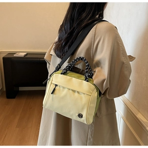Detail of multi-color nylon crossbody bag with woven handle and adjustable strap