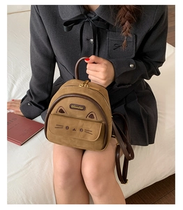 Close-up of cute cartoon cat mini backpack in brown plush with leather trim and gold zipper