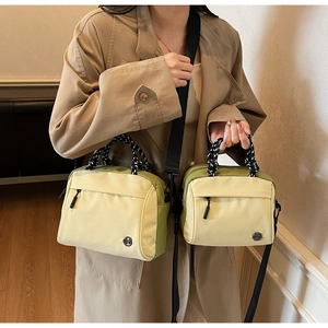 Detailed comparison of two sizes of contrasting canvas crossbody bags with woven handles