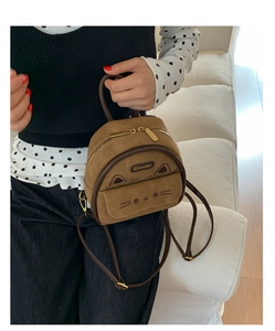 Detail of a brown cat-shaped mini backpack with embroidered whiskers and 3D ears