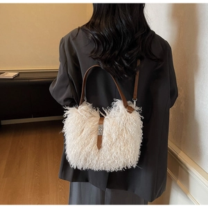 Detail of white faux fur tote bag with brown leather handles and silver metal turn-lock