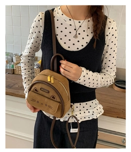 Detail of cute cat-shaped mini backpack in brown faux leather with 3-way straps