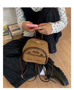 Close-up of brown suede mini cat backpack featuring cute ear 3D details and golden zipper