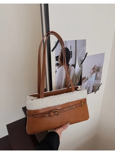Detailed close-up of brown faux leather tote with white plush trim and brand lettering