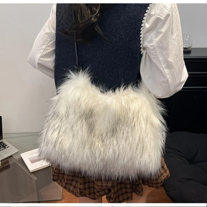 Detailed view of oversized fluffy faux fur tote bag in cream white with black leather strap