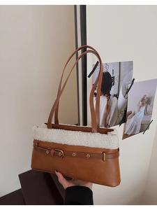 Detailed close-up of brown bag with white faux fur trim and gold buckle accent