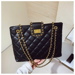 Détail du sac en cuir matelassé noir avec bandoulière en chaîne dorée et fermoir rotatif