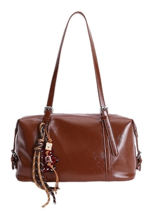 Vintage brown oil wax leather shoulder bag with cute bear charm and tassel on white background