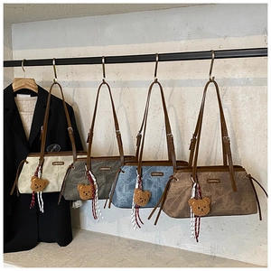 Detailed row of vintage style shoulder bags in four colors with bear charms