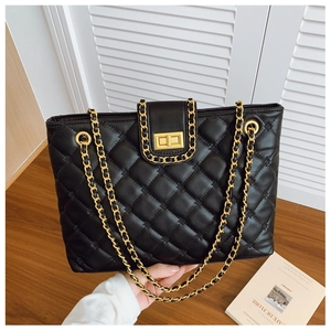 Détail du sac cabas en cuir matelassé noir avec chaîne dorée et fermoir métallique