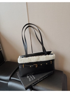 Detail of the black leather shoulder bag with white plush trim and golden buckle detail