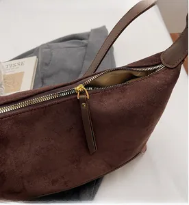 Detailaufnahme von goldenem Reißverschluss und braunem Wildleder an der Leoparden-Tasche