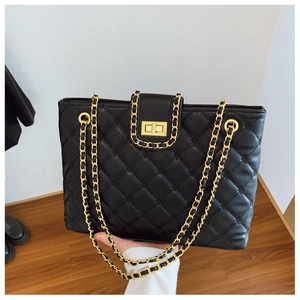 Détail du sac cabas matelassé noir avec bandoulière chaîne dorée et fermoir rotatif chic
