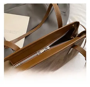 Detail view of the silver metal zipper closure on a vintage brown leather tote handbag