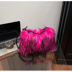Detail of faux fox fur shoulder bag in bright rose pink and black with leather strap