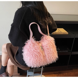 Detail of pink faux fur bucket bag with leather strap and metal clasp on shoulder