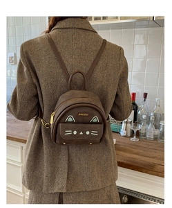 Close-up of small brown PU leather backpack with cat face design on human back