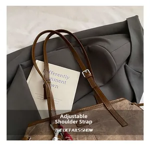 Close-up of adjustable slim shoulder straps on a vintage brown leather tote bag