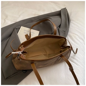 Retro brown faux leather tote bag with silver zipper and spacious interior on bed