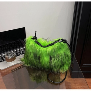 Detailed macro view of vibrant green faux fur texture and black leather handle on handbag