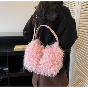 Detail of pink faux shearling tote bag with leather handles and silver metal twist lock