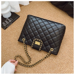 Détail du sac bandoulière en cuir matelassé noir avec fermoir doré et chaîne